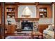 Cozy Gathering room with a stone fireplace and built-in shelves at 10029 Whistling Elk Dr, Littleton, CO 80127