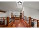 Open upper hallway with skylight and hardwood floors at 10029 Whistling Elk Dr, Littleton, CO 80127