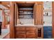 Built-in wet bar with glass shelving and wine storage at 10029 Whistling Elk Dr, Littleton, CO 80127