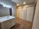 Bathroom with bright vanity lighting and a large closet with multiple doors at 8330 Zuni St # 117, Denver, CO 80221