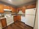 Kitchen with white appliances, wood cabinets and countertops and dark wood flooring at 8330 Zuni St # 117, Denver, CO 80221