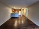 Open-concept living room with a view of the kitchen and dark wooden floors at 8330 Zuni St # 117, Denver, CO 80221