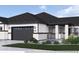 Beautiful home with a stone and siding exterior, complemented by a dark garage door and manicured landscaping at 834 W 128Th Pl, Westminster, CO 80234