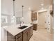 Open-concept kitchen with large island, stainless steel sink, and view of the living area at 834 W 128Th Pl, Westminster, CO 80234