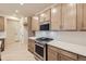 Kitchen boasts stainless steel appliances, tan cabinetry, white countertops, and decorative backsplash at 834 W 128Th Pl, Westminster, CO 80234