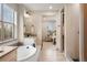 Bathroom showcasing soaking tub, large window and a door to the adjoining bedroom at 15252 W Warren Dr, Lakewood, CO 80228