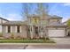 Charming two-story home with a tile roof, stone accents, and lush landscaping at 15252 W Warren Dr, Lakewood, CO 80228