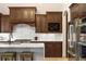 Gourmet kitchen with marble countertops, wood cabinets, and stainless steel appliances at 15252 W Warren Dr, Lakewood, CO 80228