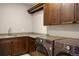 Well-equipped laundry room features modern appliances, ample counter space, and dark wood cabinetry at 15252 W Warren Dr, Lakewood, CO 80228
