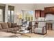 Open-concept living room with dining nook and kitchen views, featuring hardwood floors and modern furnishings at 15252 W Warren Dr, Lakewood, CO 80228