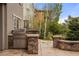 Outdoor kitchen featuring a stainless steel grill, stone accents, and landscaped surroundings at 15252 W Warren Dr, Lakewood, CO 80228
