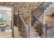 Elegant staircase with decorative iron railings and a stone accent wall at 15252 W Warren Dr, Lakewood, CO 80228