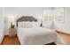 Bright bedroom featuring hardwood floors, a comfortable bed, and natural light from corner windows at 2035 Carr St, Lakewood, CO 80214