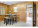 Cozy dining area with wood paneling featuring a modern table and stools, adjacent to doorway to an outdoor area at 2035 Carr St, Lakewood, CO 80214