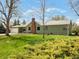 Charming single-story home featuring a green exterior, brick chimney, and a well-manicured front lawn at 2035 Carr St, Lakewood, CO 80214