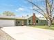 A well-maintained single-story house with a light green exterior, a spacious driveway and attached garage at 2035 Carr St, Lakewood, CO 80214