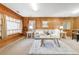 Cozy living room featuring natural wood paneling, plush seating, and a large window for ample natural light at 2035 Carr St, Lakewood, CO 80214
