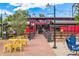 Outdoor patio with tables, string lights, and flowers at the Beer Garden Edgewater at 2035 Carr St, Lakewood, CO 80214