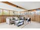 Inviting sunroom featuring wood paneling, comfortable seating, and large windows offering serene outdoor views at 2035 Carr St, Lakewood, CO 80214