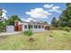 Spacious backyard with lush lawn, mature trees, a brick patio and a shed at 206 Troy St, Aurora, CO 80011
