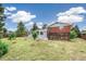 Expansive backyard featuring lush lawn, mature trees, and a charming patio area at 206 Troy St, Aurora, CO 80011