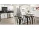 Modern kitchen showcasing stainless appliances, marble countertops, a subway tile backsplash, and three bar stools at 206 Troy St, Aurora, CO 80011