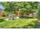 Lush, landscaped backyard with mature trees and patio offers a private outdoor living space at 11412 W Roxbury Pl, Littleton, CO 80127
