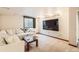 Finished basement with a white couch, large window, and a mounted television at 11412 W Roxbury Pl, Littleton, CO 80127