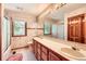 Classic bathroom featuring a dual sink vanity, large mirror, and tiled shower at 11412 W Roxbury Pl, Littleton, CO 80127