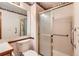 Bathroom featuring a glass shower door, patterned wallpaper and a large vanity at 11412 W Roxbury Pl, Littleton, CO 80127