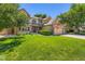 Charming two-story home with lush green lawn, mature trees, and an attached three-car garage at 11412 W Roxbury Pl, Littleton, CO 80127
