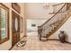 Grand foyer with staircase, decorative rug, and tile flooring leading to living spaces at 11412 W Roxbury Pl, Littleton, CO 80127