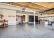 Spacious garage with ample storage, epoxy flooring, and secure access door at 11412 W Roxbury Pl, Littleton, CO 80127