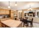 Cozy kitchen with a tile island, wooden cabinets, and an adjoining dining area at 11412 W Roxbury Pl, Littleton, CO 80127