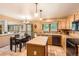 Kitchen with a tile island, wooden cabinets, and an adjoining dining area overlooking the living room at 11412 W Roxbury Pl, Littleton, CO 80127