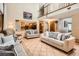 Open-concept living room featuring tile flooring, a soaring ceiling, and a view of the kitchen at 11412 W Roxbury Pl, Littleton, CO 80127