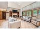 Comfortable living room with a brick fireplace, built-in shelving, and natural light from large windows at 11412 W Roxbury Pl, Littleton, CO 80127