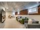 Basement living area with exposed brick, a finished ceiling and a plush green couch at 4456 Yates St, Denver, CO 80212