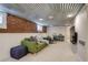 Finished basement featuring exposed brick wall, and cozy seating area with plush green sofa at 4456 Yates St, Denver, CO 80212