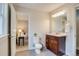 Bathroom with a wooden vanity, light gray floors, and a view into the bedroom at 4456 Yates St, Denver, CO 80212