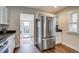 Bright kitchen featuring stainless steel refrigerator, white cabinets, and hardwood floors at 4456 Yates St, Denver, CO 80212
