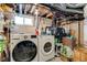 The laundry room features a full-sized washer and dryer set, storage shelves, and a small window for natural light at 4456 Yates St, Denver, CO 80212