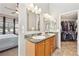 Bathroom with dual sinks, framed mirrors, and walk in closet access at 7141 S Versailles St, Aurora, CO 80016