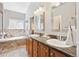 Beautiful bathroom features a soaking tub, double vanity, and natural light at 7141 S Versailles St, Aurora, CO 80016