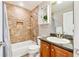 Bathroom with tiled shower and tub combo, decorative storage, and a vanity sink at 7141 S Versailles St, Aurora, CO 80016