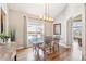 Bright dining room with hardwood floors, stylish chandelier, and picturesque window views at 7141 S Versailles St, Aurora, CO 80016