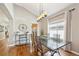 Elegant dining room featuring hardwood floors, modern chandelier, and a large window at 7141 S Versailles St, Aurora, CO 80016