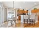 Inviting eat-in kitchen with wood cabinets, bar seating, and modern lighting fixtures at 7141 S Versailles St, Aurora, CO 80016