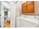 Convenient laundry area with modern washer and dryer, storage cabinet, and closet at 7141 S Versailles St, Aurora, CO 80016