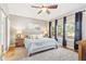 Serene main bedroom featuring plush carpeting, a ceiling fan, and large windows with natural light at 7141 S Versailles St, Aurora, CO 80016